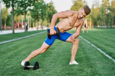 Parktaki spor egzersizinde şişirilmiş vücutlu bir sporcu.