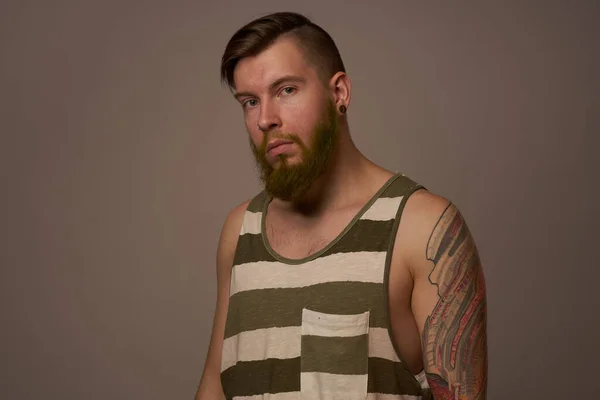 Hombre de moda con tatuajes en sus brazos elegante peinado estudio de confianza — Foto de Stock