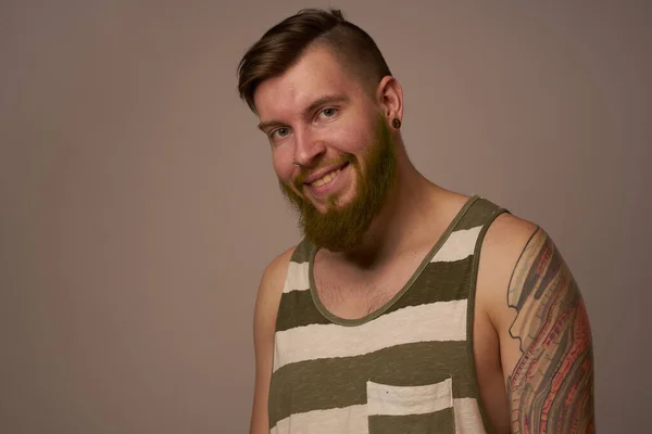 Homem barbudo nacional em uma camisa listrada hipster tatuagens em seus braços — Fotografia de Stock