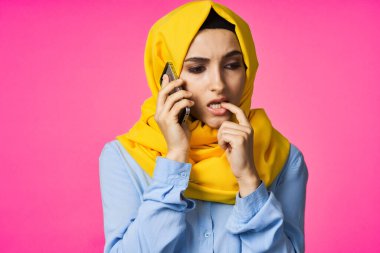 tesettürlü Müslüman kadın telefon iletişim teknolojisi pembe arka plan
