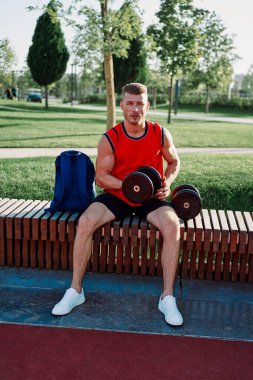 Spor salonunda kırmızı tişörtlü bir sporcu.