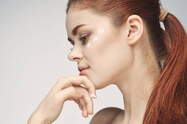 Güzel kızıl saçlı kadın temiz cilt sağlığı açık arka plan pozu veriyor