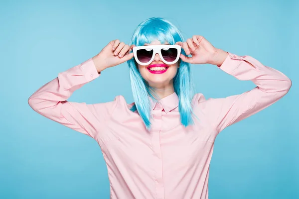 Attraktiv kvinna i lila peruk solglasögon modell blå bakgrund — Stockfoto