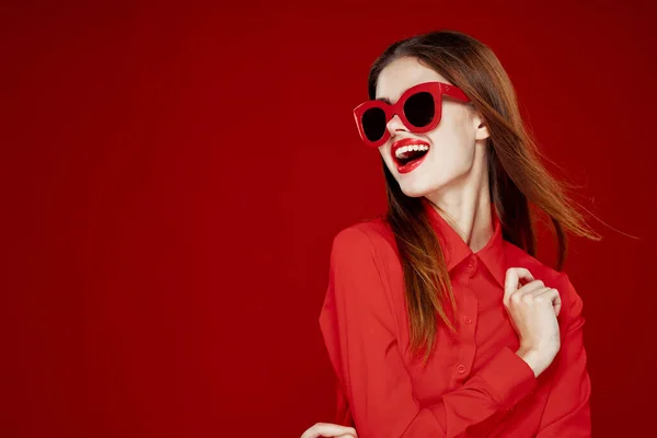 Krásná žena nosí sluneční brýle červená košile make-up izolované pozadí — Stock fotografie