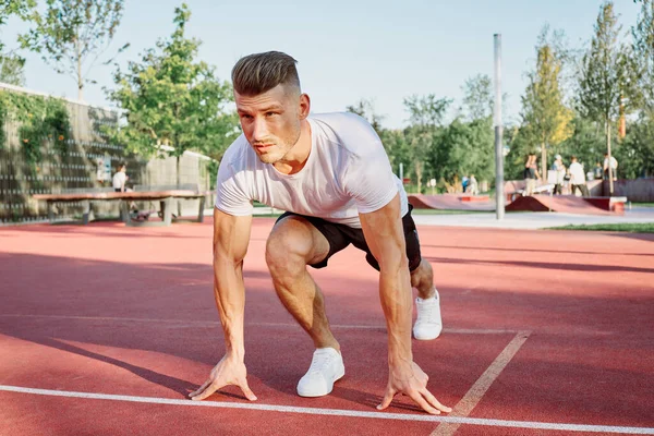 Adam dışarıda oyun sahasında egzersiz yapıyor.