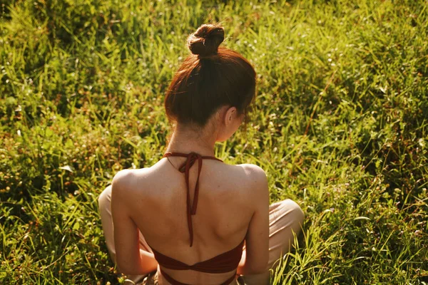 Женщина в поле сидит на траве медитации отдыха — стоковое фото