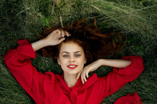 Femme en robe rouge se trouve sur l'herbe vue sur la liberté — Photo