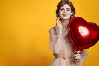 Güzel kadın kırmızı kalp balonun ellerinde izole edilmiş arka plan