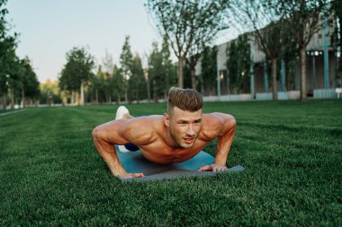 Spor kaslı adam parkta spor yapıyor.