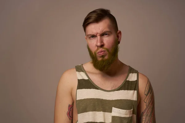 Национальный бородатый мужчина в полосатой майке татуировки хипстеров на руках — стоковое фото