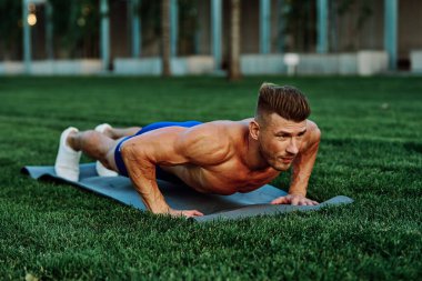 Parkta spor yapan kaslı vücutlu bir sporcu.