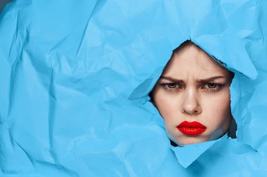 Kadın yüzü mavi arka planda kırmızı dudaklar makyaj duyguları