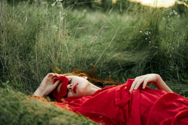 Woman in red dress lying on the grass fresh air nature romance — Stock Photo, Image