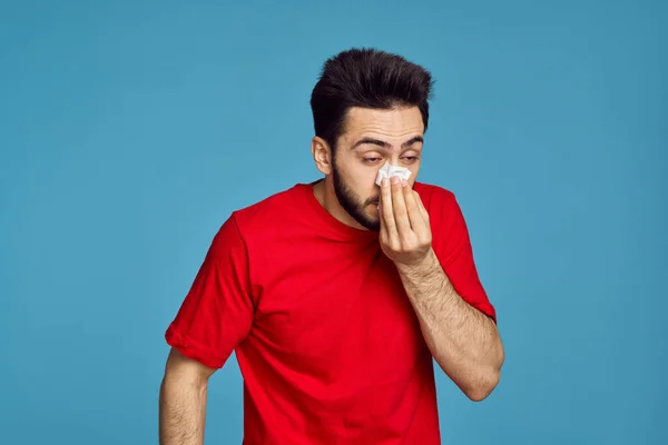 Чоловік у червоній футболці проблеми зі здоров'ям емоції синій фон — стокове фото