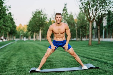 Sportif kaslı adam spor için parktaki spor motivasyonuna gidiyor.