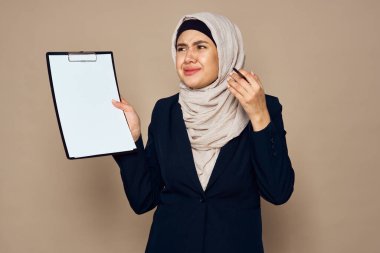 Belgeleri olan Müslüman bir kadın ofis işinde çalışıyor.