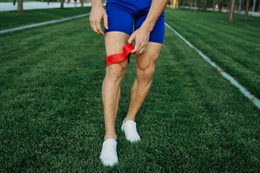 Atletik adam parkta koşma egzersizi yapıyor.