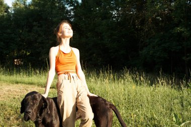 Yazın tarlada köpek dostluğuyla oynayan bir kadın.