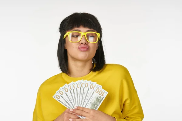 Женщина в желтом свитере с деньгами в руках весело богатства — стоковое фото