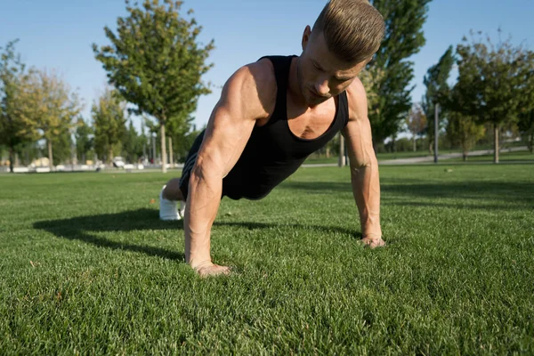 Atletische man opgepompt lichaam in het park training fitness frisse lucht — Stockfoto