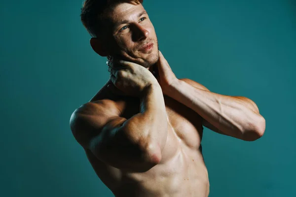 Atletische man met opgepompt gespierd lichaam workout groene achtergrond — Stockfoto