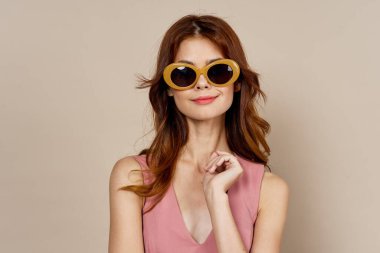 Pembe elbiseli güzel bir kadın poz veriyor.