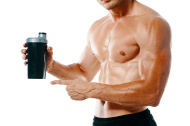 Şişirilmiş gövdesi olan atletik bir adam. Spor tükürüğü şişesi içiyor.
