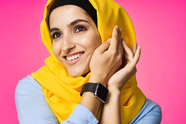 Мусульманка с технологией умных часов, позирующая розовым фоном — стоковое фото