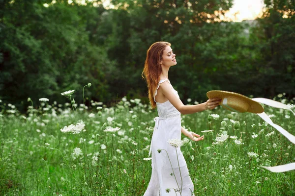 Glad kvinna i ett fält utomhus blommor frisk luft frihet — Stockfoto