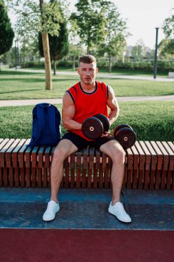 Spor salonunda kırmızı tişörtlü bir sporcu.