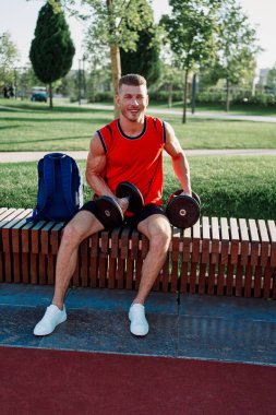 Spor salonunda kırmızı tişörtlü bir sporcu.