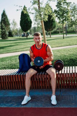 Spor salonunda kırmızı tişörtlü bir sporcu.