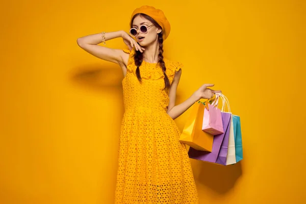 Усміхнена жінка в сонцезахисних окулярах позує на моді покупок ізольований фон — стокове фото