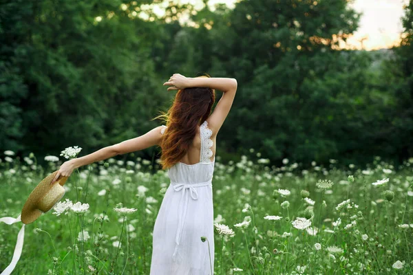 Vacker kvinna i ett fält i naturen vit klänning frisk luft — Stockfoto