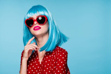 Göz kamaştırıcı mor saçlı kadın güneş gözlüğü takıyor mavi arka plan