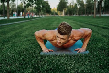 Spor kaslı adam parkta spor yapıyor.