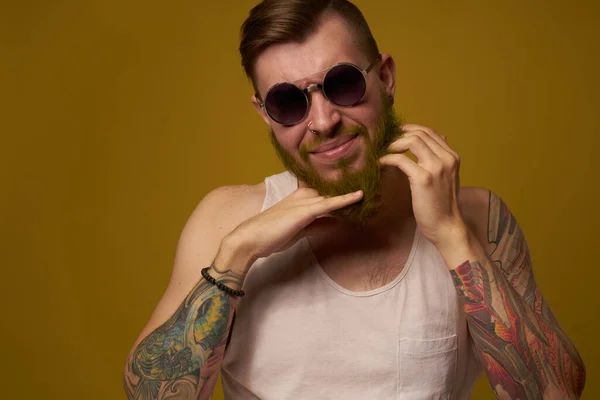 Чоловік у білій футболці татуювання на руках модні окуляри сучасного стилю — стокове фото