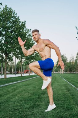 Parkta vücut egzersizi yapan atletik bir adam.