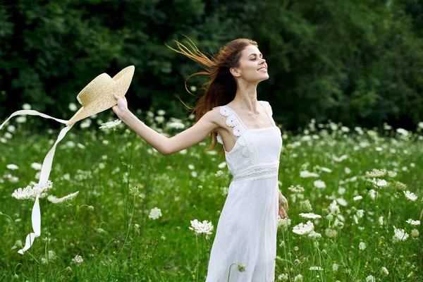 Donna in abito bianco cappello campo natura fiori — Foto Stock