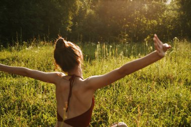 Yazın çimenlerin üzerinde oturan kadın meditasyon özgürlüğü.