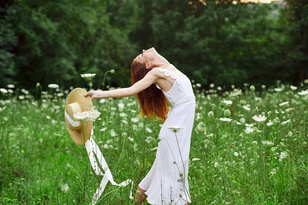 Vrolijk vrouw in een veld buiten bloemen frisse lucht vrijheid — Stockfoto