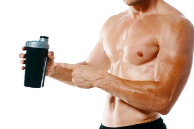 Şişirilmiş gövdesi olan atletik bir adam. Spor tükürüğü şişesi içiyor.