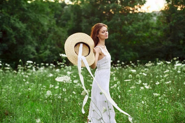Glad kvinna i ett fält utomhus blommor frisk luft frihet — Stockfoto