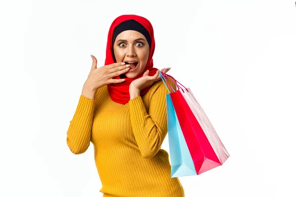 Glad muslimsk kvinna shopping semester gåvor ljus bakgrund — Stockfoto