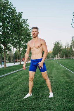 Parkta vücut egzersizi yapan atletik bir adam.