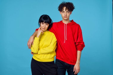 Moda kıyafetleri içinde genç bir çift. Duygularını bir arada tutuyorlar.