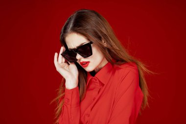 Güneş gözlüğü takan göz kamaştırıcı bir kadın.