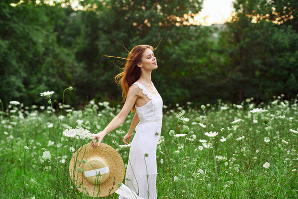 Cheerful woman in a field outdoors flowers fresh air freedom. High quality photo