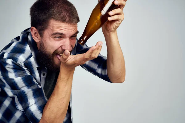 Un hombre en una camisa a cuadros beber cerveza alcohol emoción aislado fondo — Foto de Stock