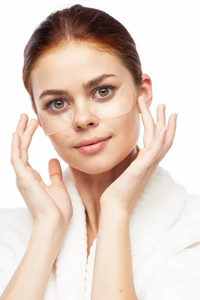 Wanita berjubah putih berpose tambalan menyenangkan perawatan kulit di wajah — Stok Foto
